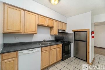 Kalamazoo house for rent - A kitchen with wooden cabinets and black countertops.