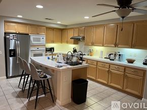 Corona house for rent - A kitchen with wooden cabinets and a white island.
