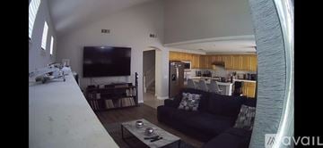 Corona house for rent - A living room with a black couch and a television.