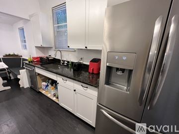 Tallahassee house for rent - A modern kitchen with a stainless steel refrigerator and white cabinets.