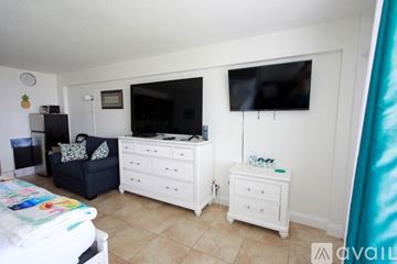 Daytona Beach apartment for rent - A bedroom with a white dresser and a television mounted on the wall.