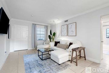 Tampa apartment for rent - A living room with a white couch and a blue rug.