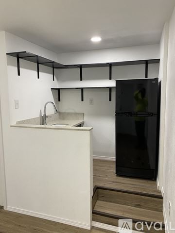 Kaneohe apartment for rent - A kitchen with white walls and a black fridge.