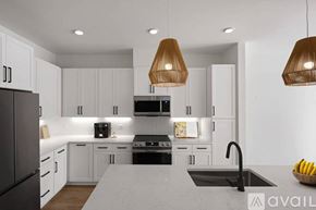 Tampa apartment for rent - A modern kitchen with white cabinets and a dark refrigerator.