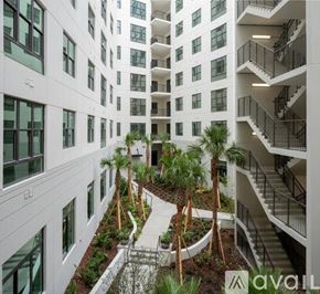 Tampa apartment for rent - A modern building with a courtyard and palm trees.
