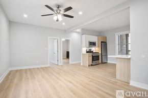 Chicago apartment for rent - A spacious living room with a kitchenette and a ceiling fan.