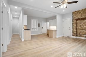 Chicago apartment for rent - A spacious room with wooden floors and a ceiling fan.