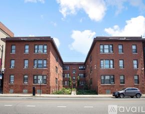 Chicago apartment for rent - A red brick apartment building with a car parked in front.