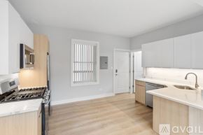 Chicago apartment for rent - A kitchen with white cabinets and a wooden floor.