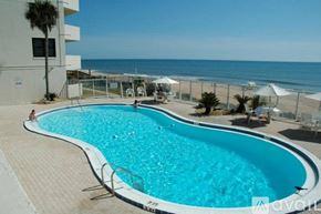 Ormond Beach apartment for rent - A large outdoor swimming pool with a person in the background.