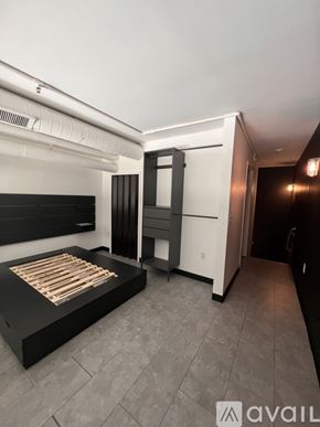 Columbus condo for rent - A bedroom with a bed, wardrobe, and a television.