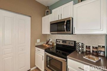 Pinellas Park apartment for rent - A kitchen with white cabinets and a black stove top oven.