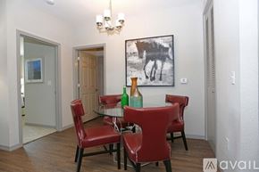 St. Petersburg apartment for rent - A dining room with a chandelier, a painting of a horse, and a table with red chairs.