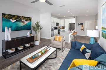 Wesley Chapel apartment for rent - A modern living room with a large painting on the wall and a blue couch.