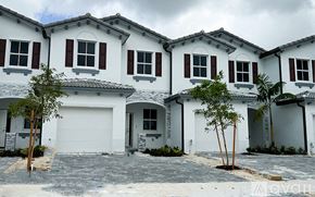 Miami-Dade County townhouse for rent - A row of white houses with brown shutters.