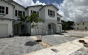 Miami-Dade County townhouse for rent - A row of houses with a tree in the middle of the driveway.