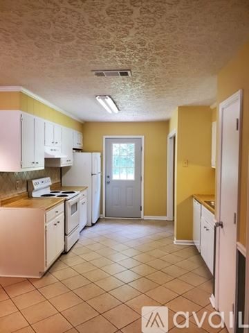 Covington apartment for rent - A kitchen with yellow walls and white appliances.