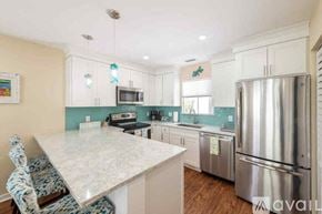 Key West condo for rent - A kitchen with a white counter top and a stainless steel refrigerator.