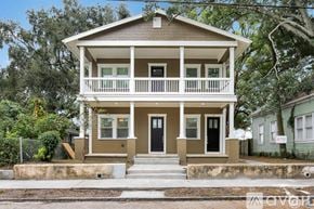 Tampa apartment for rent - A two-story house with a front porch and a black door.