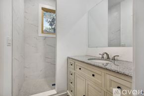 Tampa apartment for rent - A bathroom with a marble wall and a white sink.