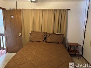 Orlando apartment for rent - A bedroom with a bed, a small table, and a ceiling fan.