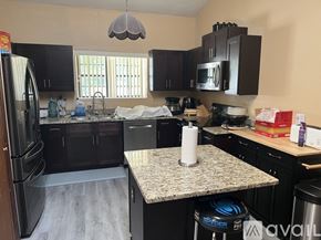 Orlando apartment for rent - A kitchen with a granite countertop and a refrigerator.