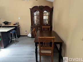 Orlando apartment for rent - A dining room with a wooden table and chairs and a large wooden cabinet.