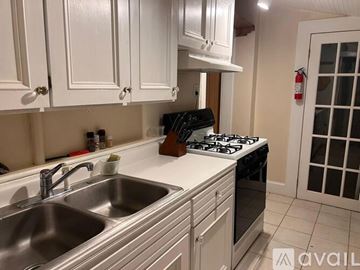 Colorado Springs house for rent - A kitchen with white cabinets and a stove top oven.