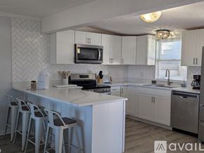 Fernandina Beach townhouse for rent - A kitchen with white cabinets and a black stove top.