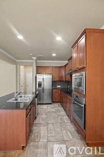 Temple house for rent - A kitchen with brown cabinets and a tile floor.