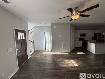 Hendersonville house for rent - A living room with a grey couch and a wooden cabinet.