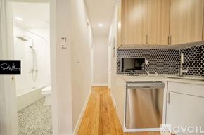 Brooklyn apartment for rent - A kitchen with a stainless steel dishwasher and wooden cabinets.