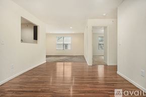 Kalamazoo apartment for rent - A spacious room with wooden floors and white walls.