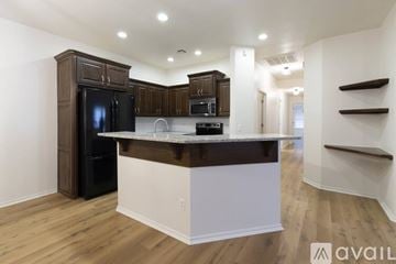 Oklahoma City house for rent - A modern kitchen with dark brown cabinets and a white island.