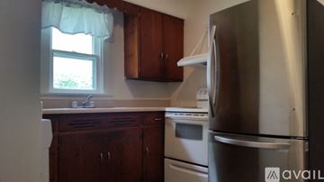 Lima house for rent - A kitchen with wooden cabinets and a stainless steel refrigerator.