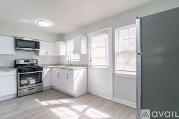 Salem apartment for rent - A kitchen with white cabinets and a grey fridge.
