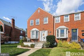 Towson house for rent - A red brick house with a blue door and a sign that says "available".