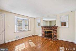 Towson house for rent - A room with a fireplace and wooden floors.
