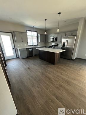 North Mankato apartment for rent - A kitchen with a wooden floor and a large island in the middle.