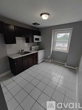 Blackwood apartment for rent - A kitchen with white tiled floors and dark brown cabinets.