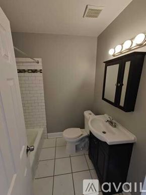 Blackwood apartment for rent - A bathroom with a toilet, sink, and mirror.