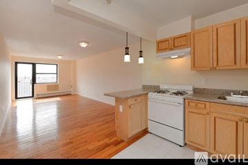 Hempstead apartment for rent - A kitchen with wooden cabinets and a white stove top oven.
