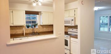 Jupiter house for rent - A kitchen with white cabinets and a window.