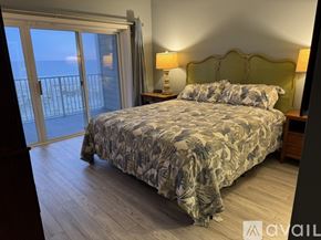 Atlantic Beach condo for rent - A bedroom with a large bed and a balcony overlooking the ocean.
