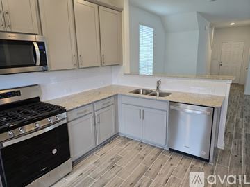 Liberty Hill house for rent - A kitchen with a black stove top oven and a white sink.