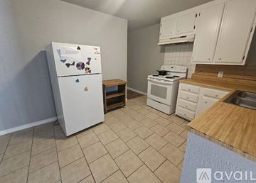 Lawton house for rent - A kitchen with white appliances and wooden countertops.