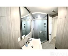 Cincinnati apartment for rent - A bathroom with a sink, mirror, and shower.