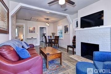 Hampton house for rent - A living room with a red couch and a fireplace.