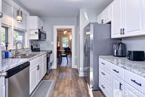 Hampton house for rent - A kitchen with white cabinets and a marble countertop.