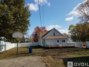 Terre Haute house for rent - A house with a white picket fence and a blue trash can in front.